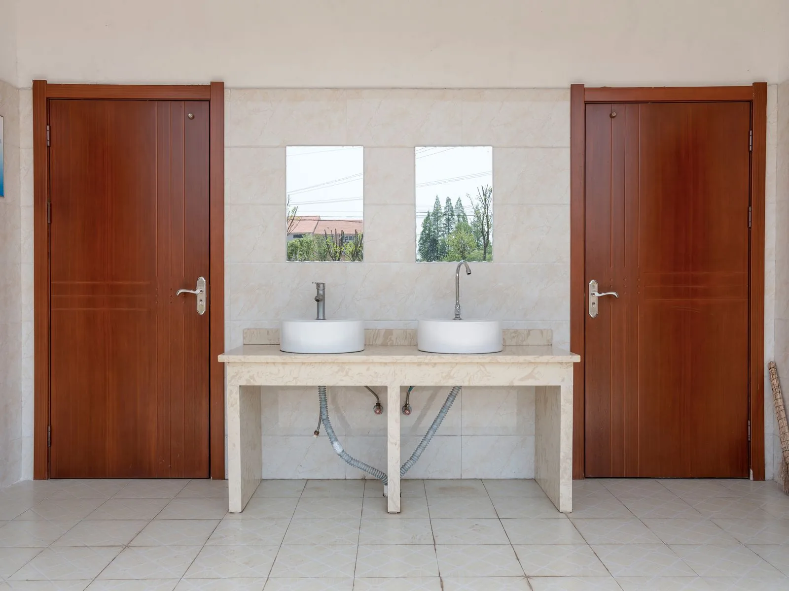 Clean, bright commercial restroom with two white sinks and mirrors